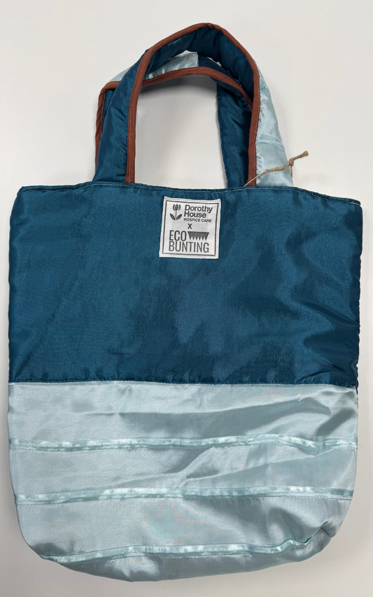 Blue and gray tote bag with a visible brand label on a white background